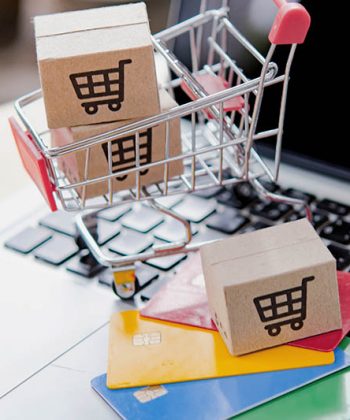 Shopping online. Credit card and cardboard box with a shopping cart logo in a trolley on laptop keyboard. Shopping service on The online web. offers home delivery